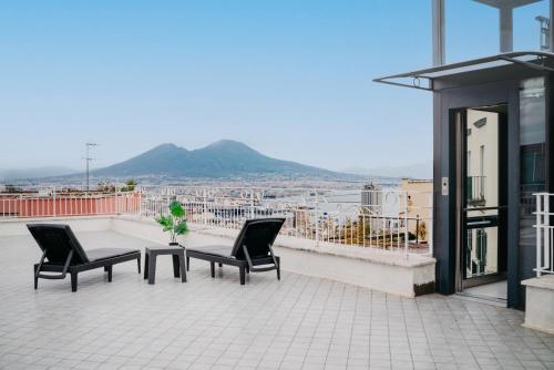 那不勒斯Vista Napoli Residence by Casa Napoletana的大楼内的阳台配有两把椅子和一张桌子