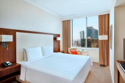 利雅德利雅德奥拉亚万怡酒店的卧室设有白色的床和大窗户