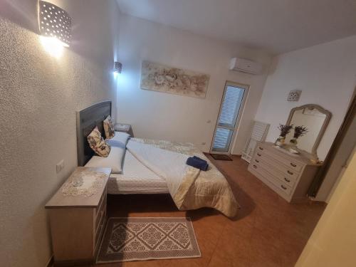 阿尔扎凯纳Appartamento Monte Mare Arzachena的一间卧室配有一张床、梳妆台和镜子