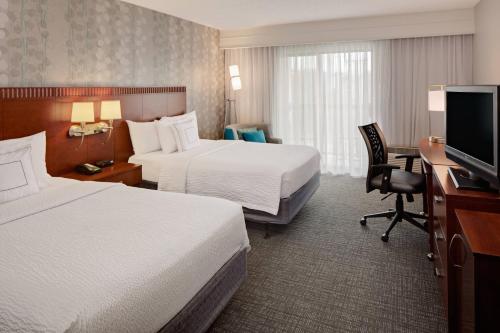 沃思堡西沃斯堡I-30万怡酒店（靠近NAS JRB）的酒店客房设有两张床、一张桌子和一台电视。
