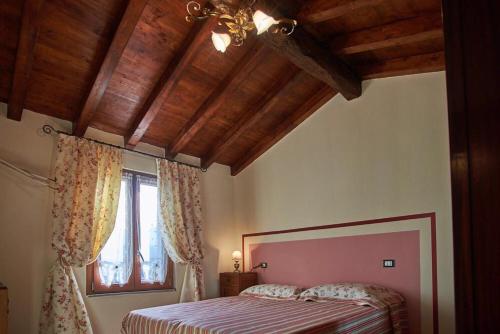 奥拉Eremo dei Poeti的一间卧室设有一张床和一个窗口