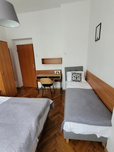 克雷尼察Zajazd Meran的客房设有两张床、一张桌子和一张书桌。