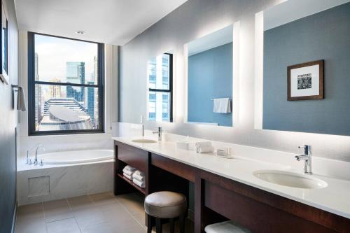芝加哥芝加哥市中心/循环原住客栈的一间带两个盥洗盆、浴缸和窗户的浴室