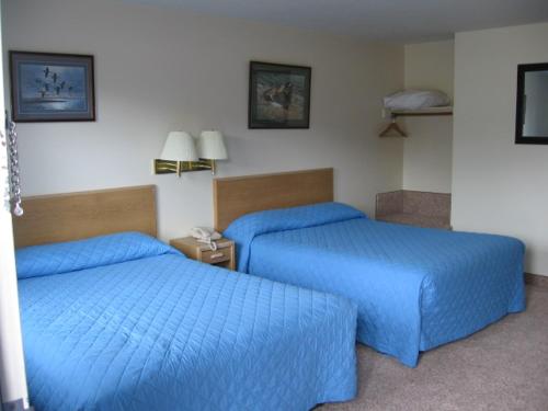 格林里弗Little Bear Motel的两张位于酒店客房的床,配有蓝色床单