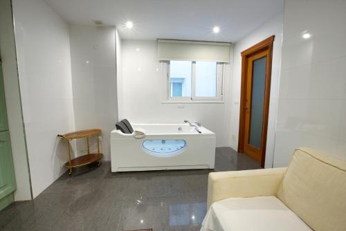 昆卡Apartamentos Chvictoria的白色的浴室设有水槽和沙发。