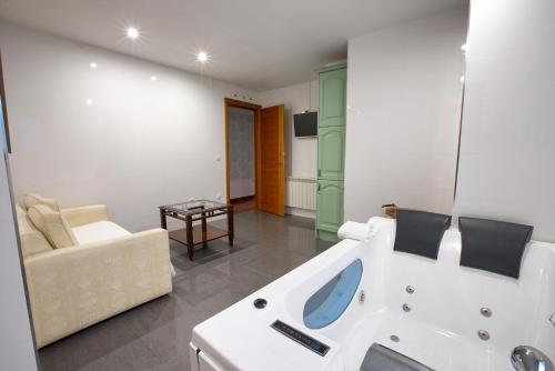 昆卡Apartamentos Chvictoria的带浴缸和沙发的浴室。