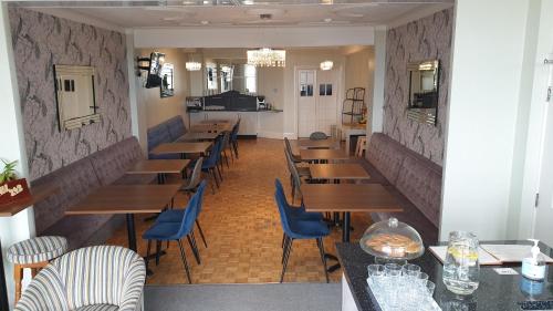 布莱克浦HOTEL242的用餐室配有木桌和蓝色椅子