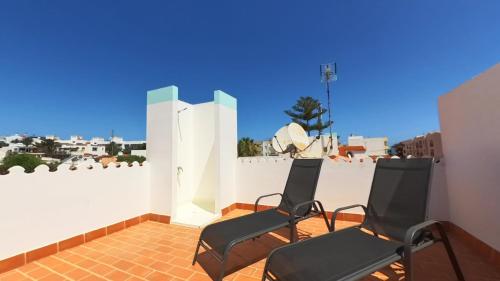科拉雷侯NÁUTICO Boutique Apartments, by Comfortable Luxury - Adults Only的两把椅子坐在带白色墙壁的庭院