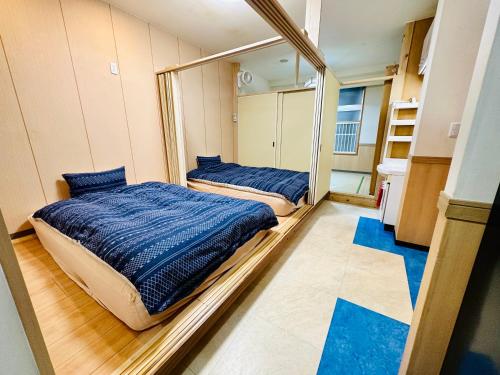 横滨MoRi House IN 伊勢佐木町的配有镜子的客房内的两张床