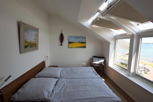 霍瓦赫特Meeresblick-Deck-44-Haus-3-WE-44的一间卧室设有一张床和一个大窗户