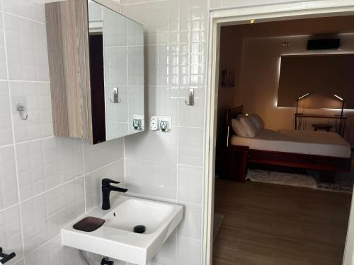 卢萨卡Smart Stay Eco Friendly AirBnB的一间带水槽的浴室和一间带床的房间