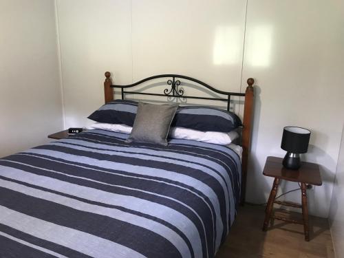 PatersonBIKABISA的一间卧室配有一张蓝色和白色条纹的床