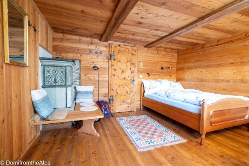 萨斯阿尔马格尔豪泽尔特拉初度假屋的小木屋的卧室,配有一张床和一张桌子