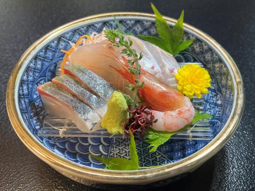 Itako割烹旅館霞ヶ浦的一张蓝色的盘子,桌子上放有寿司