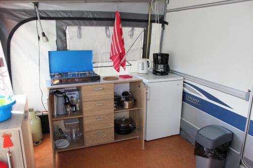 阿赫特克克Caravan 't Koekoeksnest的帐篷内的厨房配有炉灶和冰箱