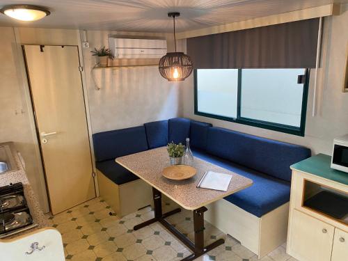 维亚雷焦Comfortabele familie chalets met veranda incl airco dichtbij zee!的一间小餐厅,配有蓝色的沙发和一张桌子