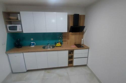 萨拉热窝Apartman Zana的小厨房配有白色橱柜和水槽