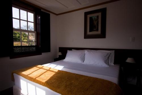 欧鲁普雷图欧维多酒店的一间卧室设有一张大床和窗户