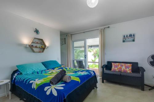 拉罗汤加Ann's Island Beach Studio的卧室配有床、椅子和窗户。