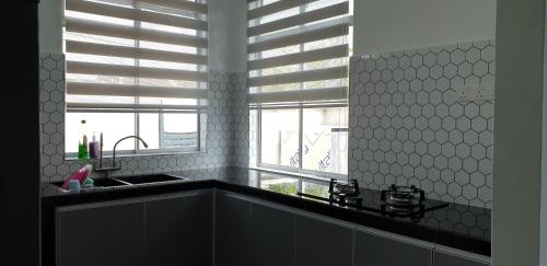Guar ChempedakEl Manzil Homestay with Pool的厨房设有水槽和窗户。