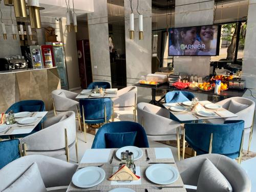 马马亚Onal Boutique Hotelier的一间带桌椅和电视的餐厅