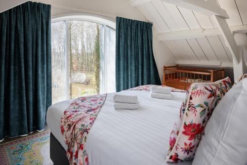 东卡佩勒Koetshuis Buitenplaats Iepenoord的一间卧室设有一张大床和一个窗户。