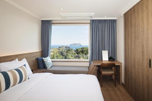 西归浦市西归浦肯辛顿度假酒店的酒店客房设有床和窗户。