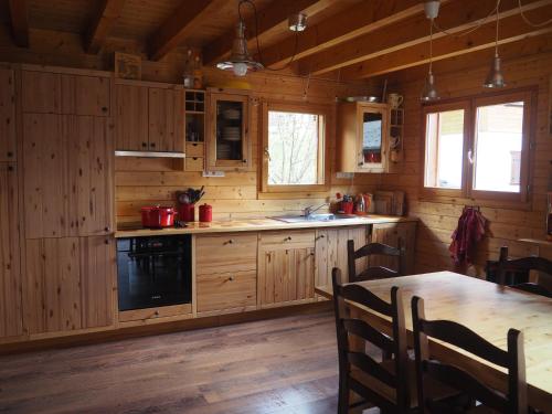 沙泰勒LATITUDE 47的小屋内的厨房配有木制橱柜和桌子