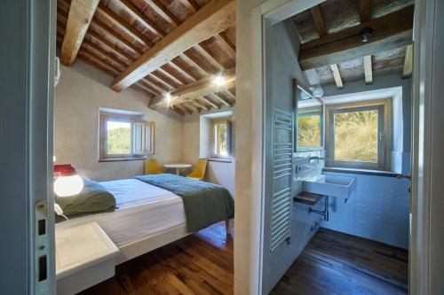 马西尼亚诺Agriturismo Montecolombo by Il Ritorno的卧室配有床和盥洗盆