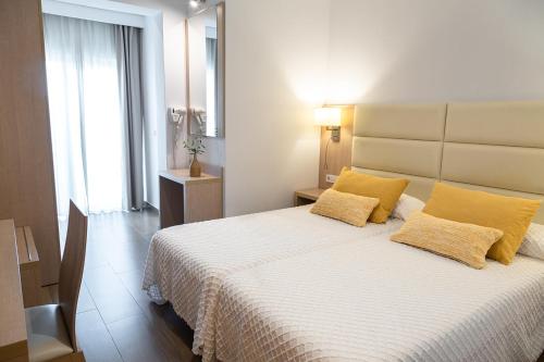 波蒂纳茨拉斯归纳旅馆的一间卧室配有一张带黄色枕头的大床