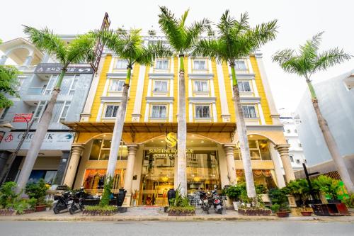 胡志明市Sunshine Boutique Hotel Phu My Hung的一座棕榈树的黄色建筑