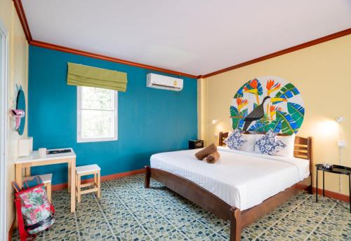 芭东海滩柠檬酒店的一间卧室设有一张床和蓝色的墙壁