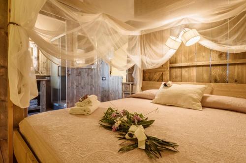 波普洛尼亚格拉姆平波焦罗索豪华帐篷的一间卧室,床上放着鲜花