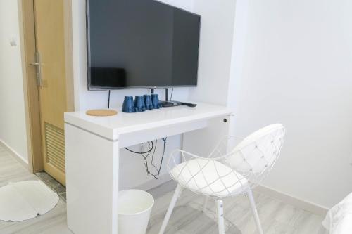 新加坡Comfy Studio 5 by ReCharge的一张带电视和两把椅子的白色书桌