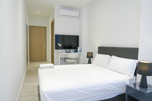 新加坡Comfy Studio 5 by ReCharge的卧室配有一张白色大床和一张书桌