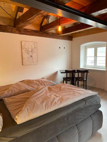 帕绍24-7 Apartment Passau的一间卧室配有一张床和一张桌子及椅子