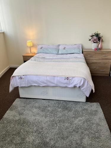 罗瑟勒姆Two Bed Town Apartment的一间卧室配有一张大床,提供紫色床单和枕头
