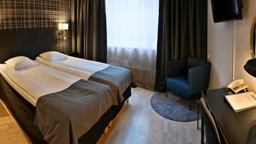 哈尔姆斯塔德阿玛德斯酒店的酒店客房,配有一张床和一张蓝色椅子