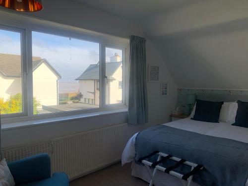 霍伊莱克Seaways Cottage Hoylake的一间卧室设有一张床和一个大窗户