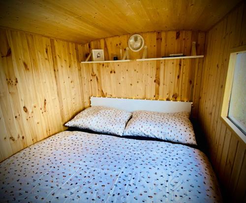 Maringotka Za Trnkou的木制客房内的一间卧室,配有一张床
