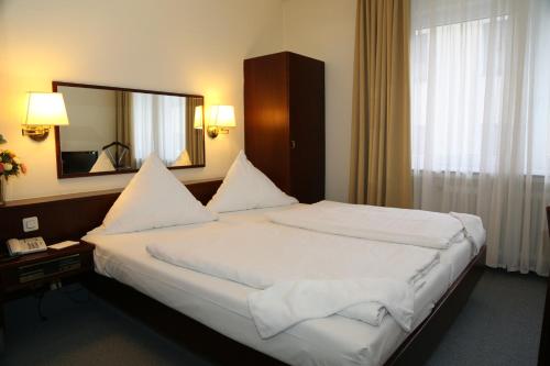 波恩伦朵夫酒店的一间卧室配有一张大床和大镜子