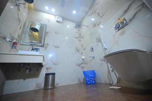 穆扎夫法尔普尔ROYAL MANSION的一间带水槽、卫生间和镜子的浴室