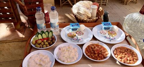 锡瓦Panta Lodge Siwa بنتا لودج سيوة的一张桌子,上面放着食物和瓶装水