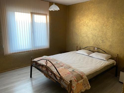 克鲁舒纳Elena的一间卧室配有一张带白色床单的床和两个窗户。