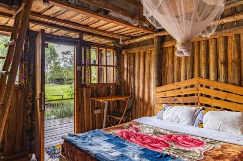 波特尔堡Kalitusi Nature Resort的木制客房内的一间卧室,配有一张床
