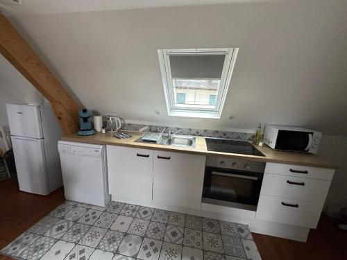 巴涅尔德比戈尔Superbe appartement proche centre ville, thermes的厨房配有白色橱柜、水槽和微波炉