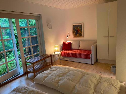 维堡Idyllically Located Wooden House By The Forest, 2的一间卧室配有一张床、一张沙发和窗户。