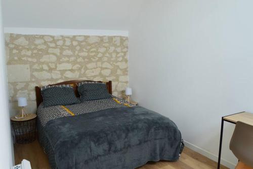 希农La Grange de l'Olive的一间卧室配有一张石墙床