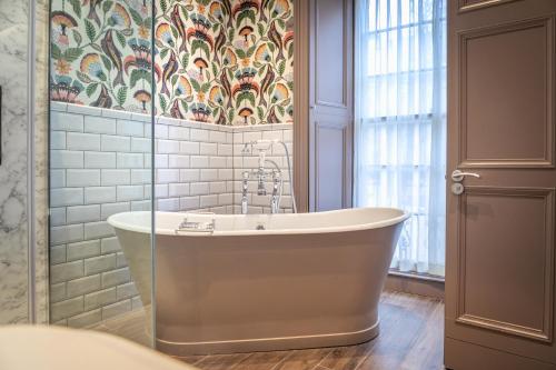 爱丁堡雷布恩酒店的带浴缸的浴室和花卉壁纸