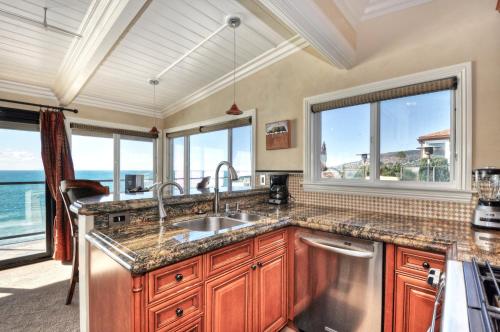 拉古纳海滩Villa Roma at the Retreat in Laguna Beach的带水槽的厨房和部分窗户